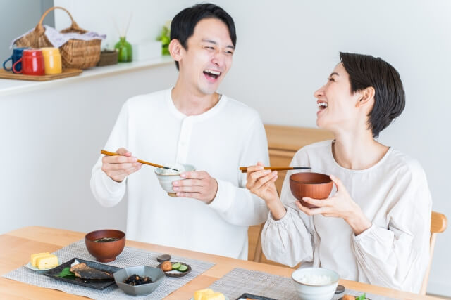 笑顔で食事をする夫婦